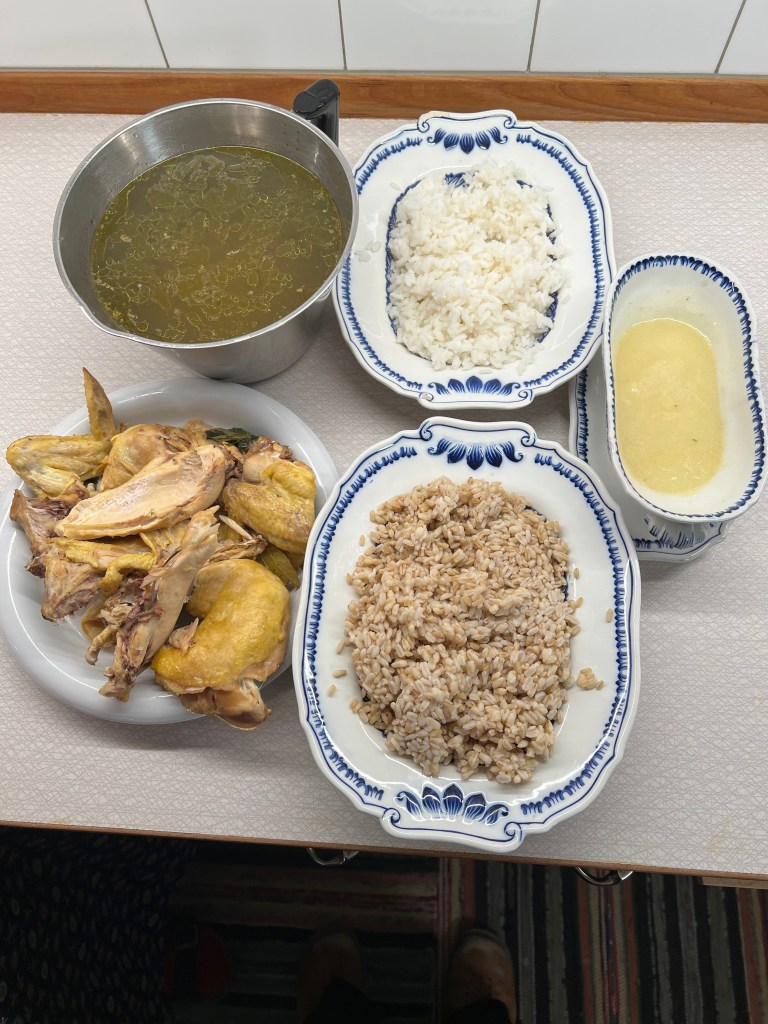 En skål med grönsaksbuljong, tallrikar med vitt och brunt ris samt en portion med kyckling.